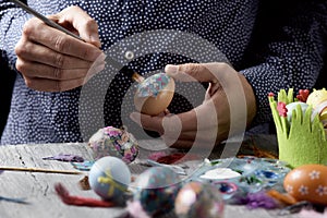 Young man decorating homemade easter eggs