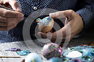 Young man decorating homemade easter eggs