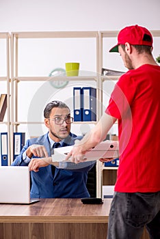 Young man delivering pizza to the office