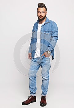 Young man in denim suit. Handsome man in denim jacket and jeans on a white background. Photo for advertising men`s jeans and