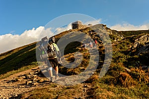 A young man descends from the top of the mountain Pip Ivan, observes the epic landscapes around the mountain, carries a large