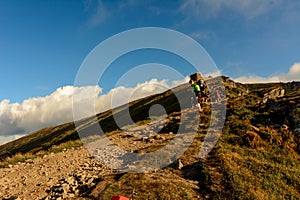 A young man descends from the top of the mountain Pip Ivan, observes the epic landscapes around the mountain, carries a large