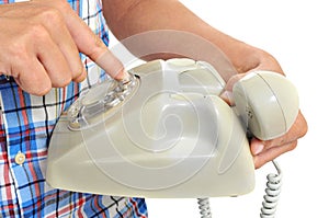 Young man dialing in a rotary dial telephone