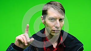 Young man disapproving with NO hand sign make negation finger gesture on green screen background.