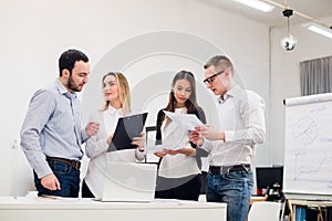 Young man discussing market research with colleagues in a meeting. Team of professionals having conversation at