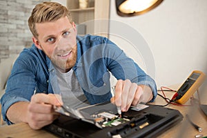 young man dismantling laptop