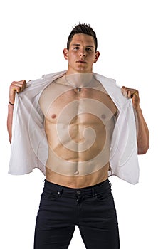 Young man displaying his muscular torso holding