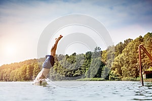 Young man diving into a lake.