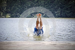 Young man diving into a lake.