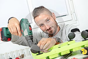 Young man DIY using electric drill