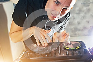 Young man DJ with mixer is working