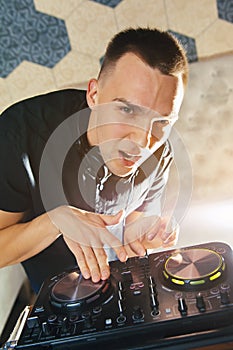 Young man DJ with mixer is working