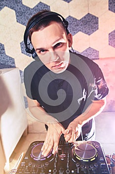 Young man DJ with mixer is working