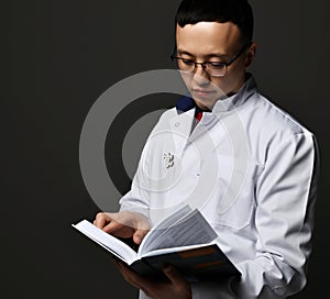 Young man doctor read book. Medicine worker. Healthcare concept on dark