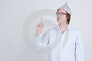 Young man doctor with tinfoil hat thinking and pointing up