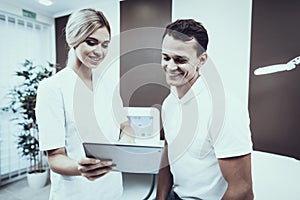 Young Man with Doctor in White Coat in Clinic.