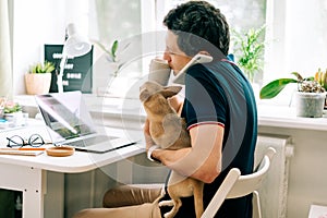 The young man with dog working from home