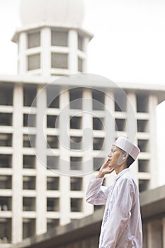 Young man doing adzan in mosque