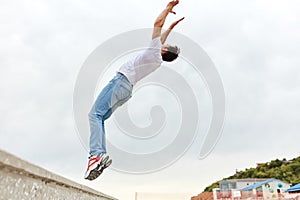 Young man doing back flip in the street. Sport Activities outdoors.