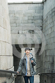Young man doing a backpacking trip in a Korean traditional castle wall