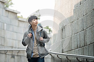 Young man doing a backpacking trip in a Korean traditional castle wall