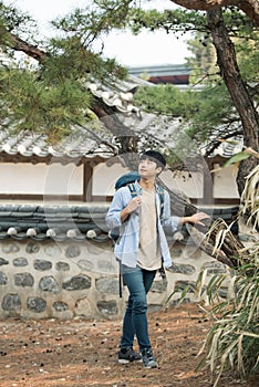 Young man doing a backpacking trip in a Korean traditional house.