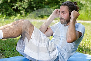 Young man doing crunches in park