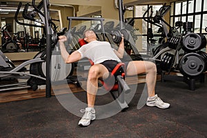 Young man doing Dumbbell Incline Bench Press workout in gym