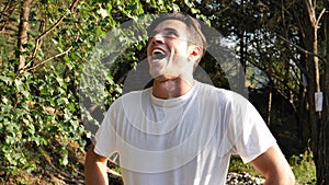 Young man doing evil laughter, outside in nature