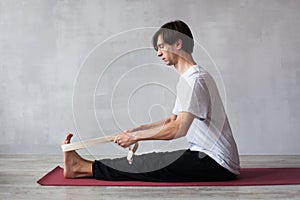 Young man in doing exercise with belt