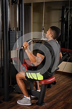 Young man doing lats pull-down workout