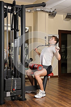 Young man doing lats pull-down workout