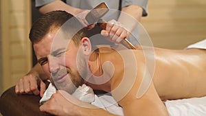 Young man doing a massage using a special hammer