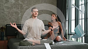 Young man doing mindfulness meditation ignoring his wife. Adit