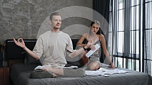 Young man doing mindfulness meditation ignoring his wife. Adit