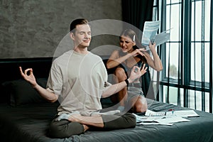 Young man doing mindfulness meditation ignoring his wife. Unveiling