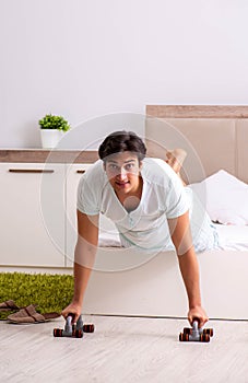 Young man doing morning routine in bedroom