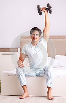 Young man doing morning routine in bedroom