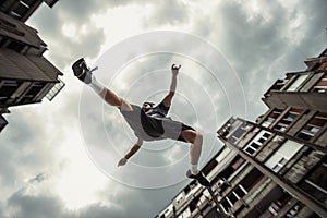 Young man doing parkour jump in the city