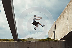 Young man doing parkour jump in the city