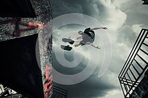 Young man doing parkour jump in the city