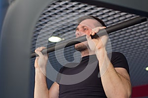 A young man doing pull ups in the Gym