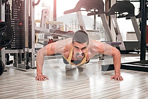 Young man doing push-ups in gym