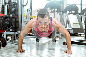 Young man doing push-ups in gym