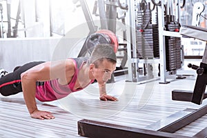 Young man doing push-ups in gym