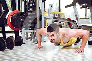 Young man doing push-ups in gym