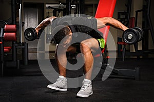 Young man doing Seated Bent Over Dumbbell Reverse