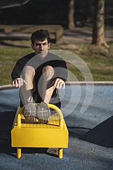 Young man doing sit-ups in the park