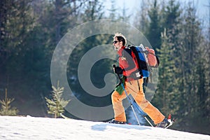 Young man doing ski touring at winter mountains on a sunny day