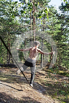 Young man doing slackline rodeo in forrest outside sports activities, lifestyle people concept